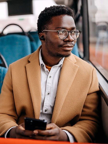 Young man on public bus using mobile phone